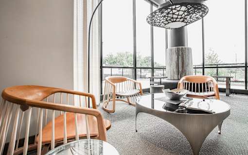 A room with a table and chairs and a hanging light fixture.