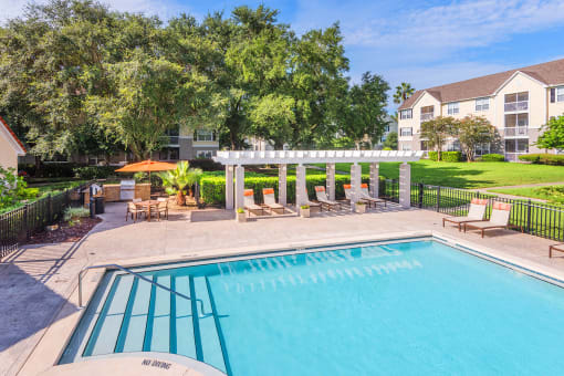 The Colony at Deerwood Apartments - Resort-style pool with pergola and BBQ
