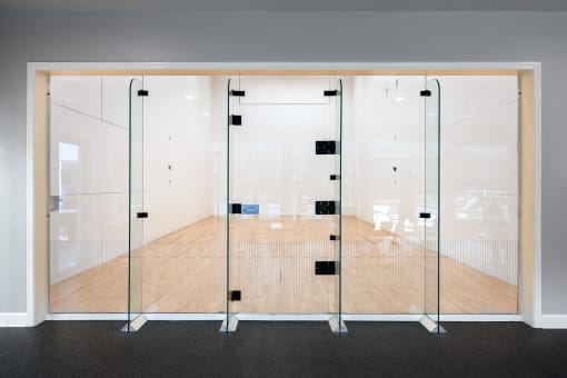 Weston Point Apartments - Indoor racquetball court with equipment available for use