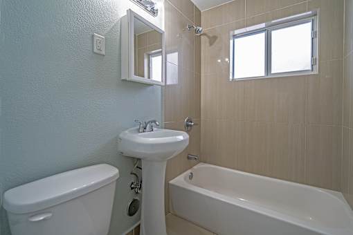 Tan tiled bath tubs in select units - Helios Apartments Miami Beach