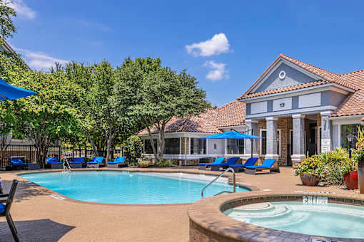 A pool with a hot tub in front of a house.