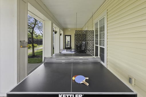 a ping pong table on the side of a house