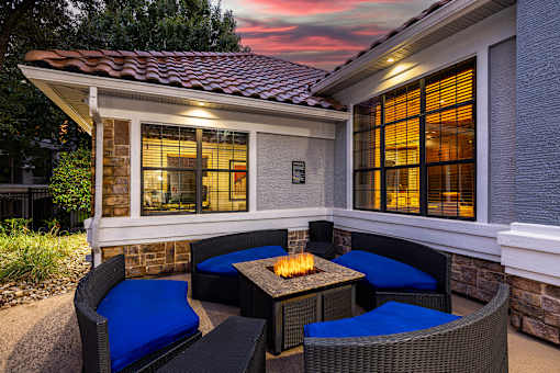 A patio with a table and chairs is set up outside a house.