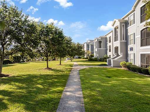 A row of houses with a concrete pathway in the foreground.