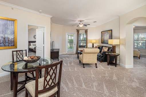 A living room with a glass table and chairs.