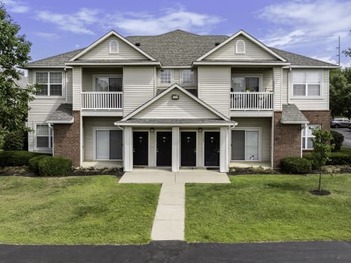 the front of a house with a sidewalk in front of it