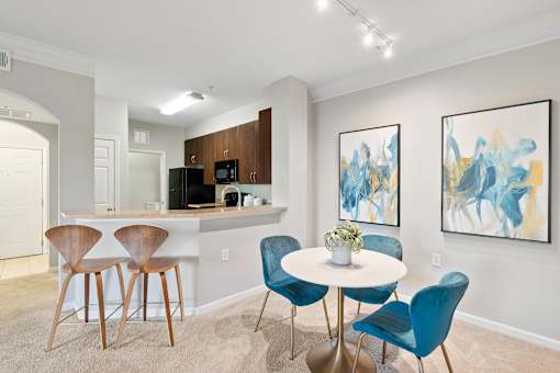 A dining area with a white table and blue chairs.