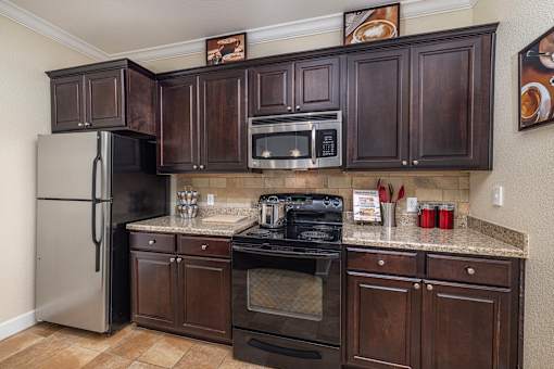 A kitchen with dark brown cabinets and stainless steel appliances.