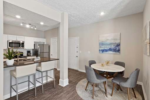 A kitchen with a bar and a dining table.