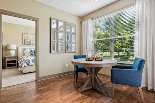 A dining room with a table and chairs.