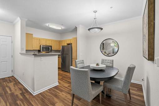 A kitchen with a table and chairs.