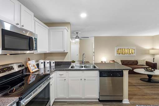 Modern kitchen with white cabinets - The Colony at Deerwood Apartments