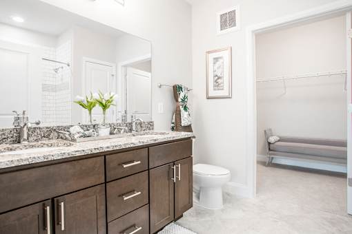A bathroom with a toilet, sink, and a mirror.