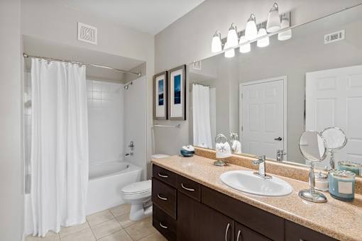 A bathroom with a white shower curtain and a white toilet.