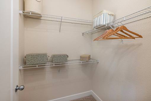A white closet with a towel and a hanger.