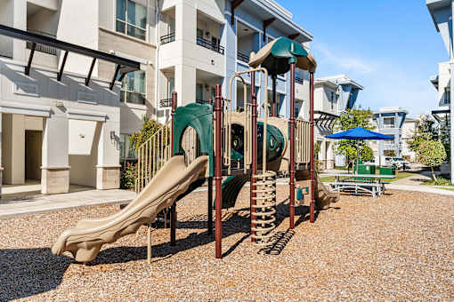 A playground with a slide and a climbing frame.