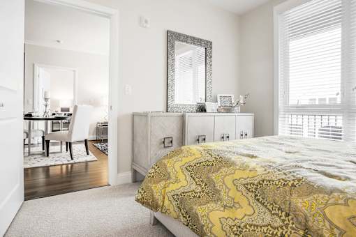 A bedroom with a bed, dresser, and mirror.
