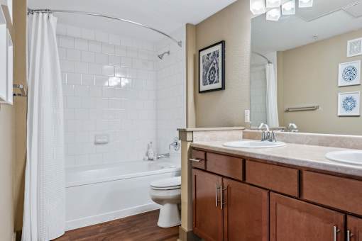 A bathroom with a white toilet and a white bathtub with a shower curtain.