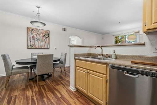 A kitchen with a table and chairs and a painting on the wall.