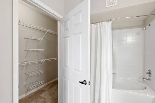 A white bathroom with a white tub and a white shower curtain.