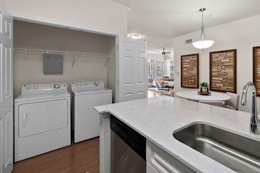A modern kitchen with white appliances and a marble countertop.