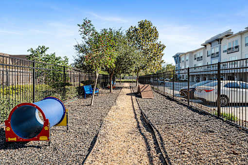 A playground with a blue slide and a red and yellow slide.