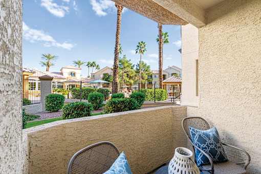 A patio with a chair and a vase on it.