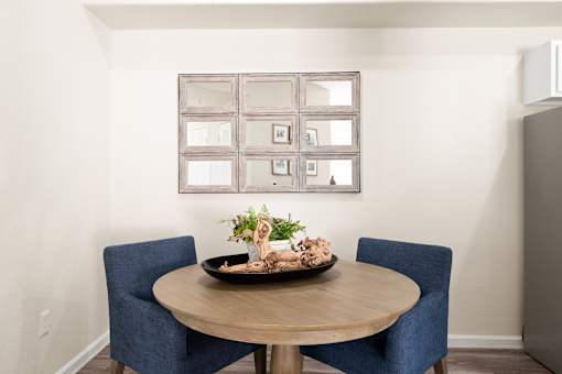 A dining table with two chairs and a decorative plant on it.