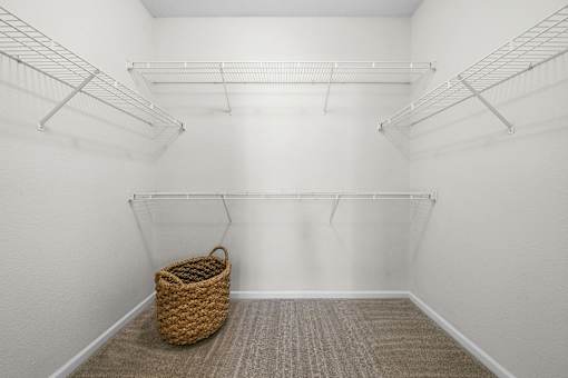 A room with white walls and a wicker basket on the floor.
