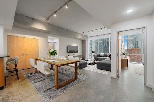 A modern kitchen with a dining table and chairs is shown.