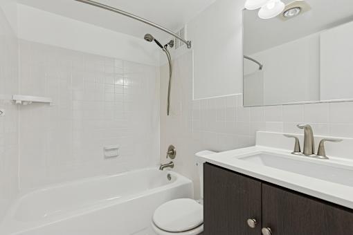 A white bathroom with a toilet, sink, and bathtub.