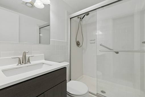 A white sink with a silver faucet is on a countertop in a bathroom.