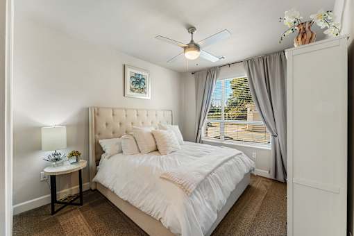 A bedroom with a large bed and a ceiling fan.