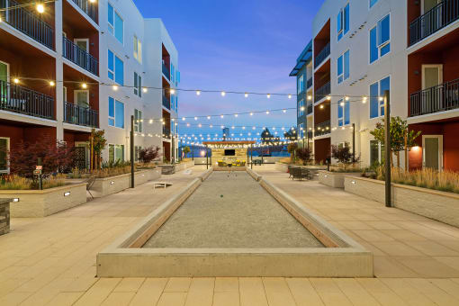 Bocce ball and outdoor fireplace in a well-lit courtyard - La Via Apartments