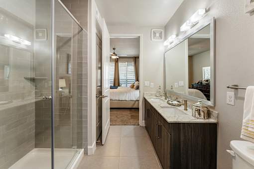 A bathroom with a walk-in shower and a large mirror.