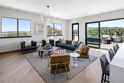 A living room with a large window and a view of the mountains.