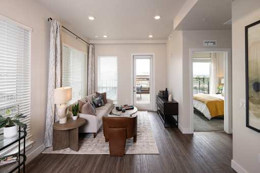 A well-lit, modern living room with a large window and a comfortable seating area.