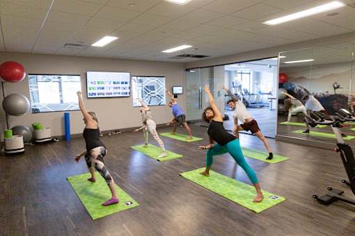 A group of people are exercising in a gym.