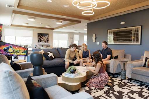 A group of people are sitting around a table in a modern living room.