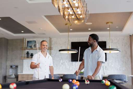 Two men playing pool in a well-lit room.