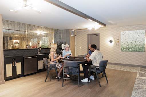 Four people sitting around a table in a modern kitchen.