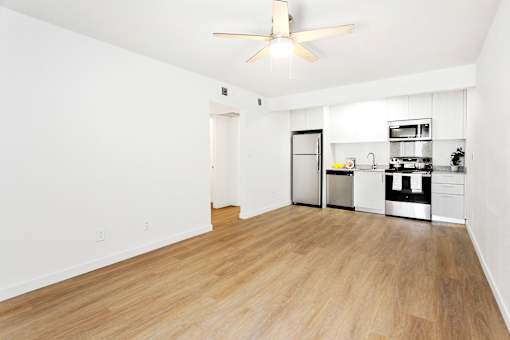 A kitchen with white walls and wooden floors.