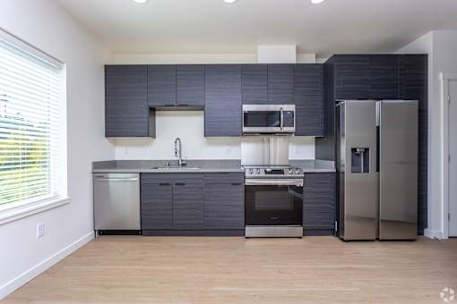 A modern kitchen with stainless steel appliances and dark grey cabinets. at Plisko Place, Port Orchard