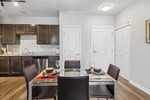 A modern kitchen with a dining table set for two.