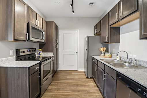 A kitchen with dark wood cabinets and stainless steel appliances.