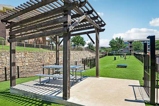 A wooden pergola is over a picnic table.