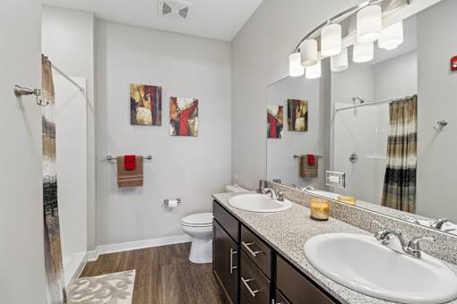 A bathroom with a toilet, sink, and mirror.
