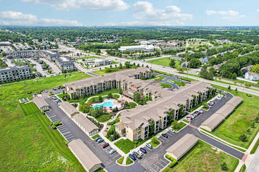A large apartment complex with a pool in the middle of the courtyard.