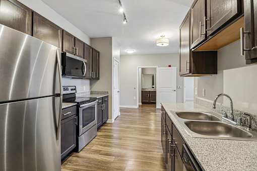 A modern kitchen with a stainless steel refrigerator and wooden cabinets.