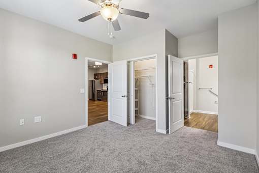 A room with a ceiling fan and carpeted floor.
